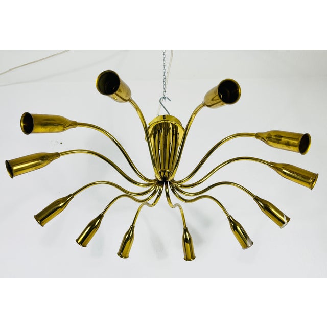 A Sputnik chandelier made in Italy in the 1950s. It is fascinating with its twelve brass arms, each of it with an E14...