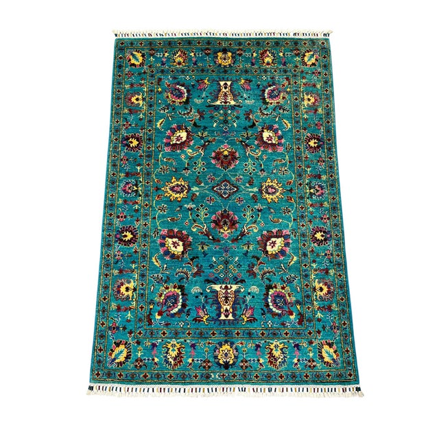 This Sultani area rug brings a traditional Persian-inspired floral design to a bright turquoise field. Large flowers and...
