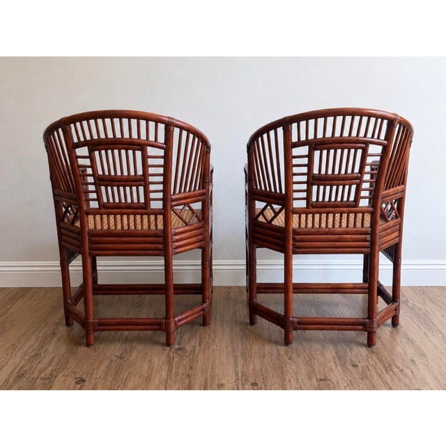 Striking pair of vintage Brighton Pavilion–style bamboo and rattan armchairs featuring a rich mahogany-toned finish and...