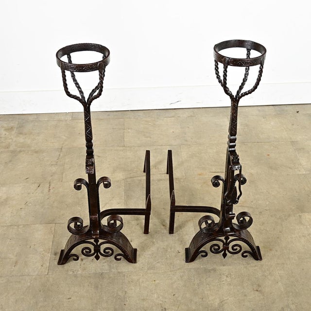 A towering pair of French 18th century forged, wrought iron andiron-chenets to watch over the hearth. They include a small...