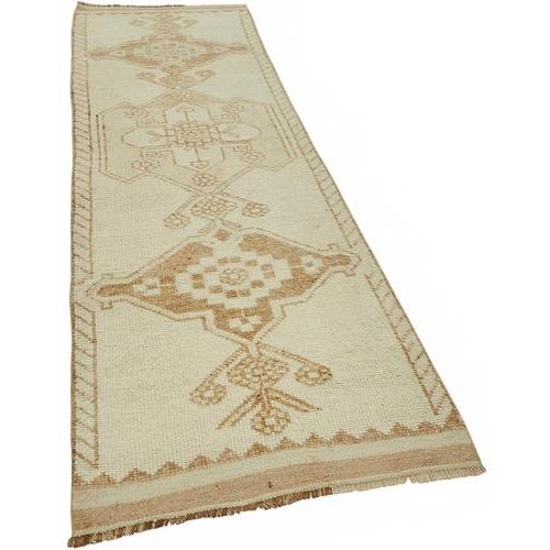 This exquisite runner rug is a rare example of tribal craftsmanship, hand-knotted by the women of the Herki tribe during...