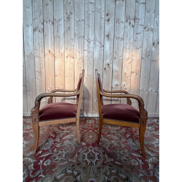 Pair of Empire-style armchairs in solid beechwood, 19th century. The scrolled armrests are carved with dolphin motifs, a...