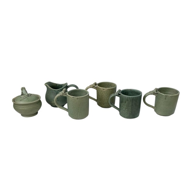 This set of six vintage coffee mugs features a charming frog pattern on a green stoneware ceramic. The mugs have a...