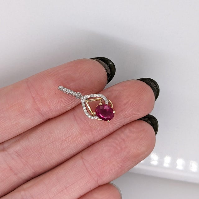 This gorgeous ruby pendant is a timeless statement piece. It is crafted with a 6x4mm oval natural ruby and encircled with...