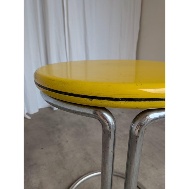 Vintage Bauhaus style side table made in the 1970s. The table features a chrome tubular steel base and a round yellow...
