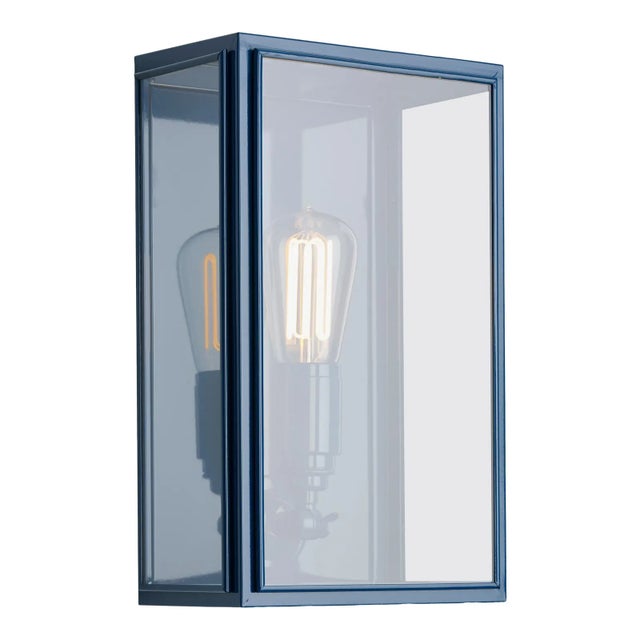 Wall light in brass lacquered in color with outside fitted clear or frosted glass and spring closure. For indoor and...