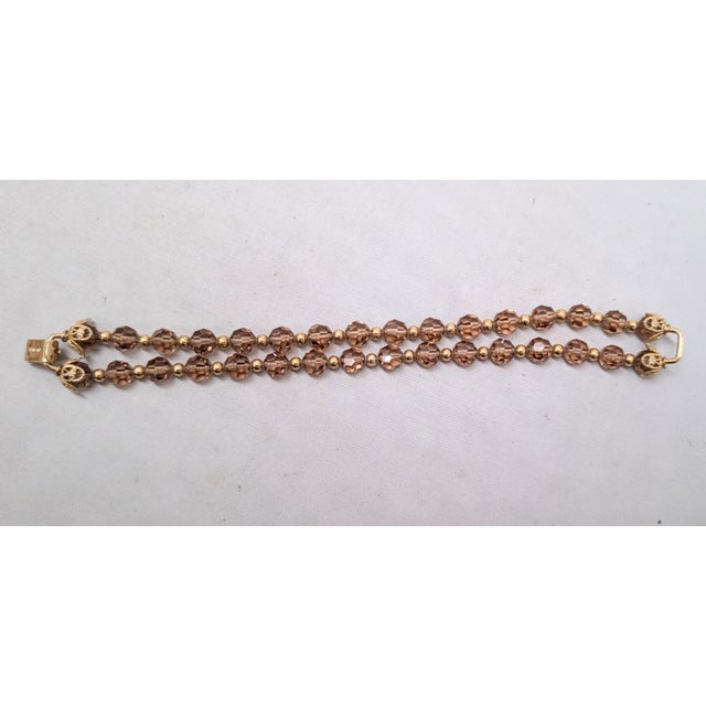 1960s goldtone 2-strand faceted faux-topaz beads with small goldtone spacer beads and filigree terminals around the ends...