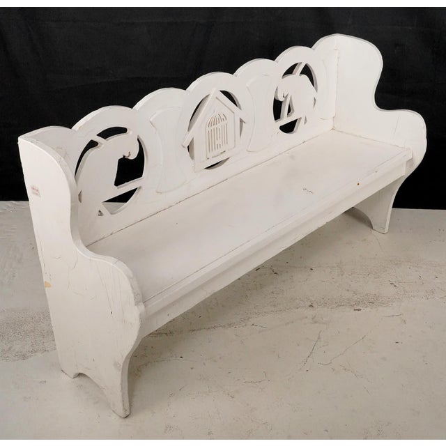 Reclaimed Folk Art children's bench made of white painted wood. The scalloped backrest is divided into three sections. The...