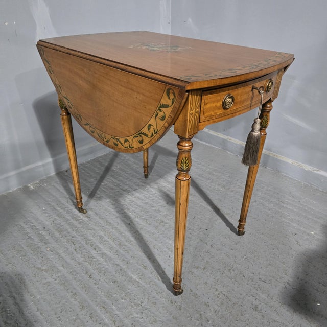A top quality oval satinwood pembroke table with painted legs and top, working key, mahogany lined, in excellent overall...