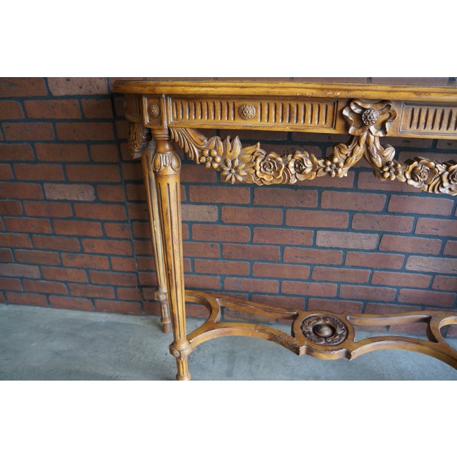 French Provincial style console table. Featuring beautiful carved bow tie swag detail with floral motif and a curvaceous...