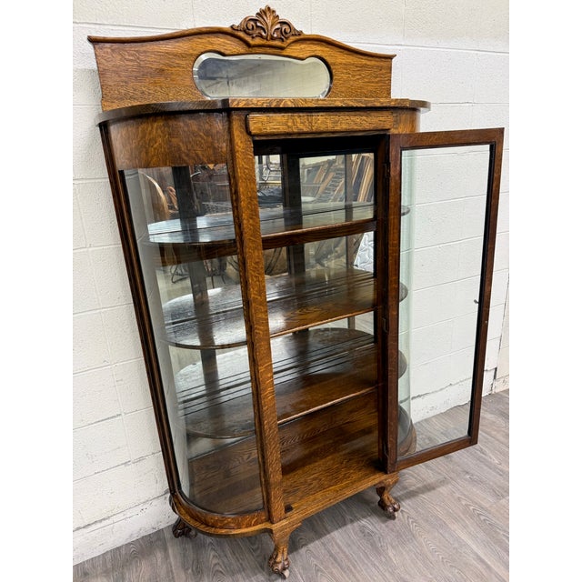 This is a stunning antique American Victorian or Edwardian quarter sawn tiger oak curved glass china cabinet or curio,...
