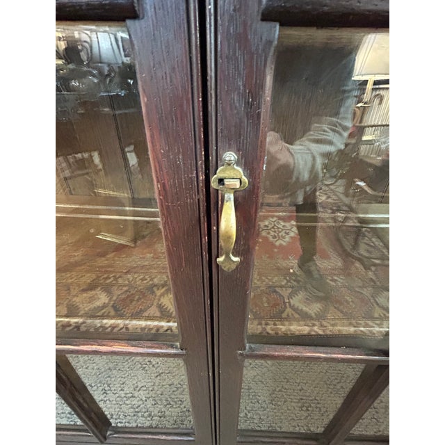 Classic vintage Mission style dark wood & glass display cabinet having panes around sides and back to allow viewing...