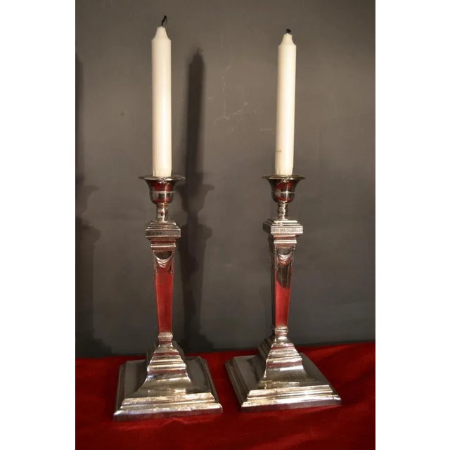 A simply elegant pair of antique early 19th century English Sheffield candlesticks . The vasiform stem is squared and...