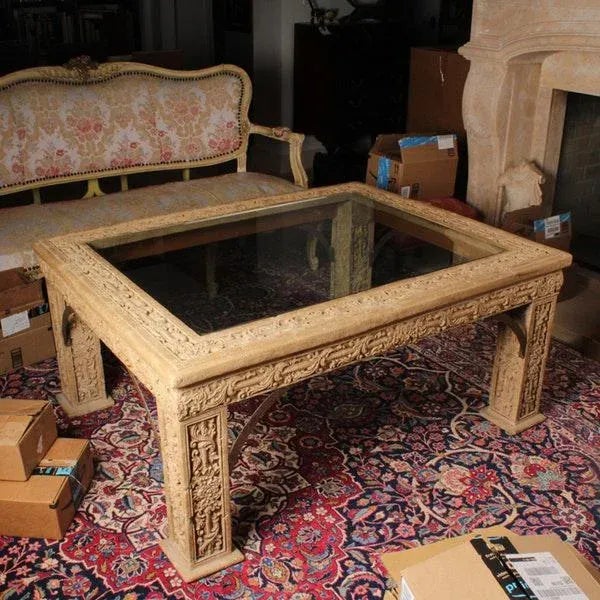 A rare vintage cast monumental faux stone coffee table with glass rectangular top. The table features a clear glass...