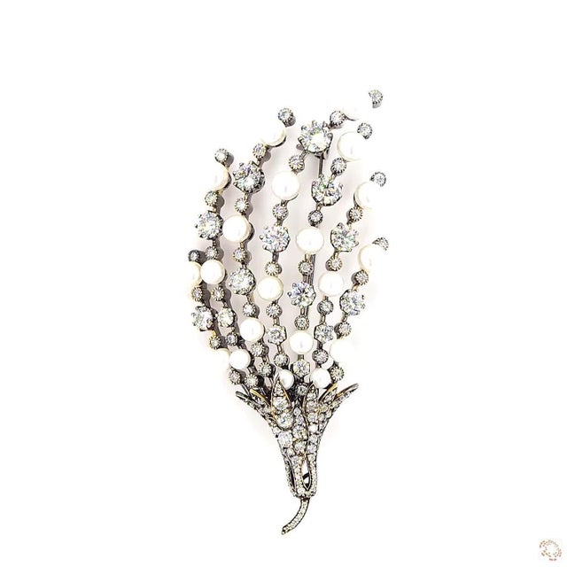 This vintage brooch, an Art Deco design, centers on a 9.0-carat pearl in a rounded ball form. It is framed by diamond...