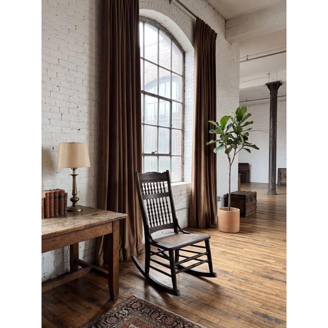 Antique rocking chair dating to the late 19th to early 20th century. Constructed in wood, likely oak, with turned legs and...