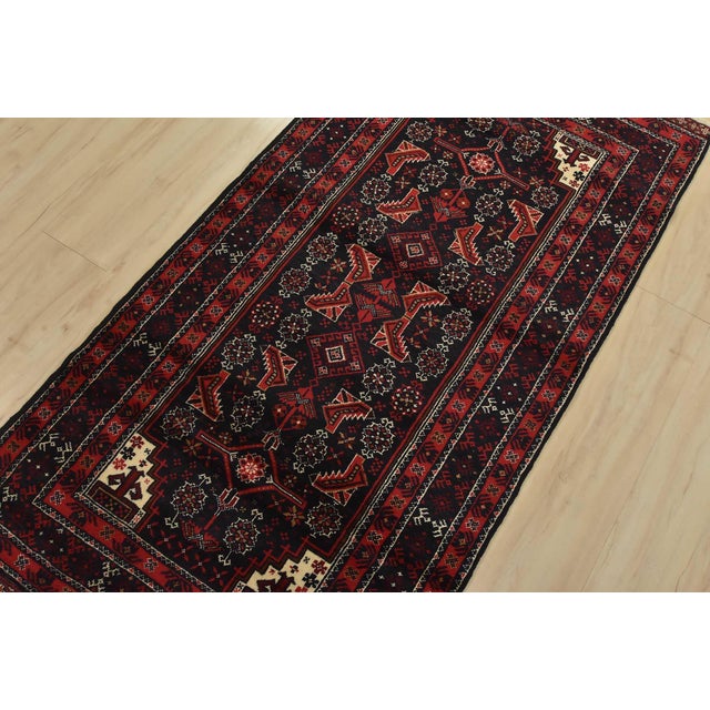 An authentic vintage tribal Baloch rug hand-knotted with fine wool and natural dyes. This nomadic rug features a geometric...