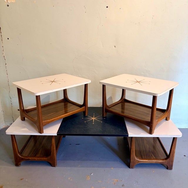 Marvelous three-piece Mid-Century Modern table set featuring a coffee table and two matching end tables. The set has...