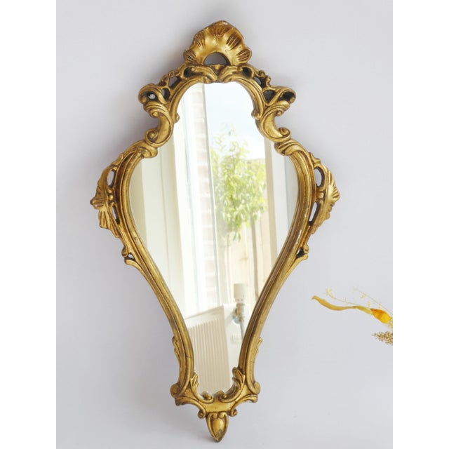 A beautiful vintage French gold mirror. The mirror has a nice gilded ornate frame with a nice antique look patina. In good...