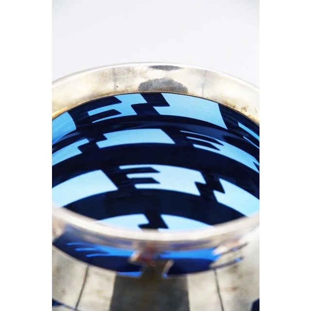 Gorgeous vintage blue glass vase designed by Bacarat in the 1920s. The vase is made of silvered metal in the structure and...