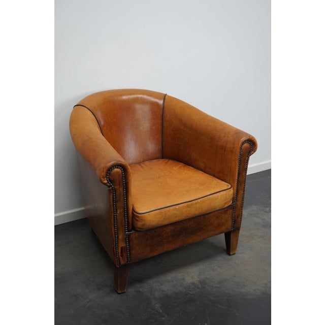 This cognac-colored leather club chair comes from the Netherlands. It is upholstered with cognac-colored leather and...