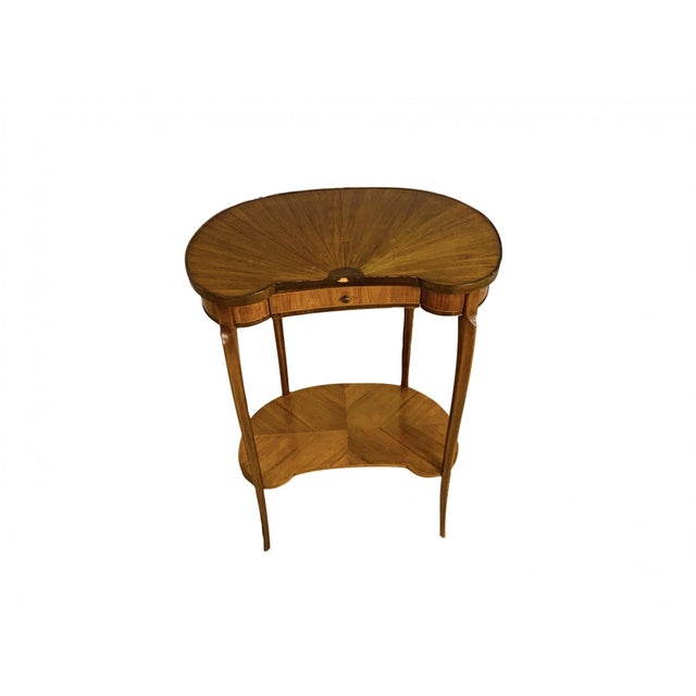 A French style kidney or bean-shaped occasional table in a warm honey to medium brown tone with a single drawer, two...