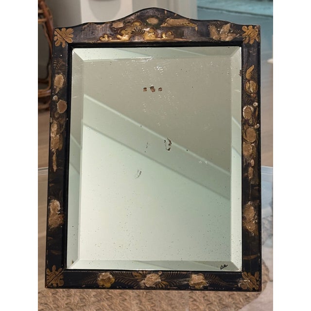 Antique diminutive scale English dressing mirror constructed with a black lacquer frame decorated by hand in gilt and...