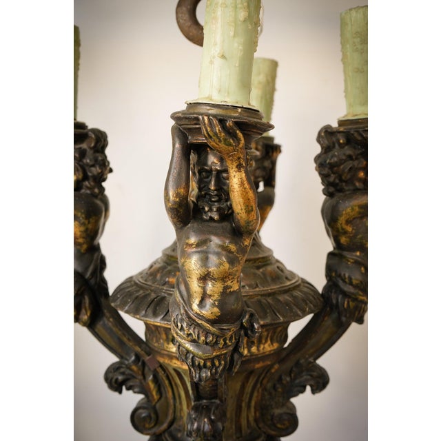 Chandelier with four greek mythological figures holding each electrified bulb holder. Approx date: first half of the 20th...