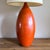 A sculptural 1960s ceramic table lamp in the manner of Jacques and Dani Ruelland, with a vivid orange glaze and...
