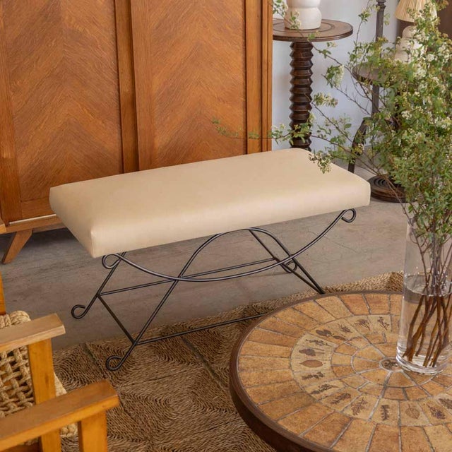 Iron bench with beautiful curved and looped base with matte black painted finish. Rectangular cushioned seat upholstered...
