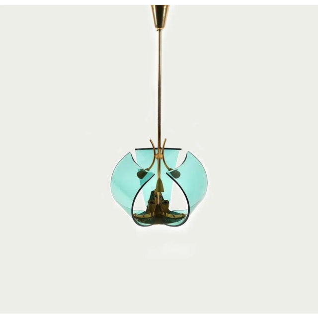 Midcentury amazing chandelier in brass and glass with fittings for six lights, suspended from a brass rod and conical...