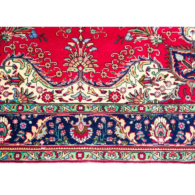 A beautiful mid-20th century Persian Tabriz rug with a large central floral medallion living amidst a field of flowers...