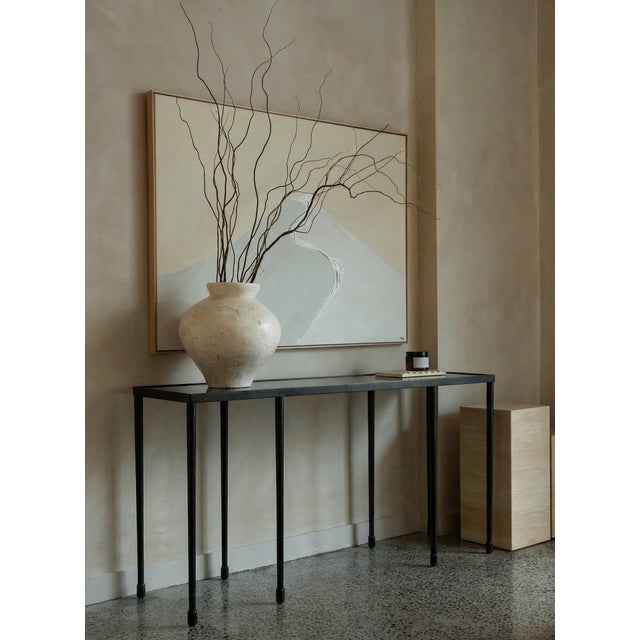 A striking black iron console table that brings industrial elegance to any entryway or living space. Its sturdy metal...