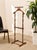 A handsome vintage gentleman’s valet stand in warm walnut, designed to keep a jacket, trousers, tie, and everyday...