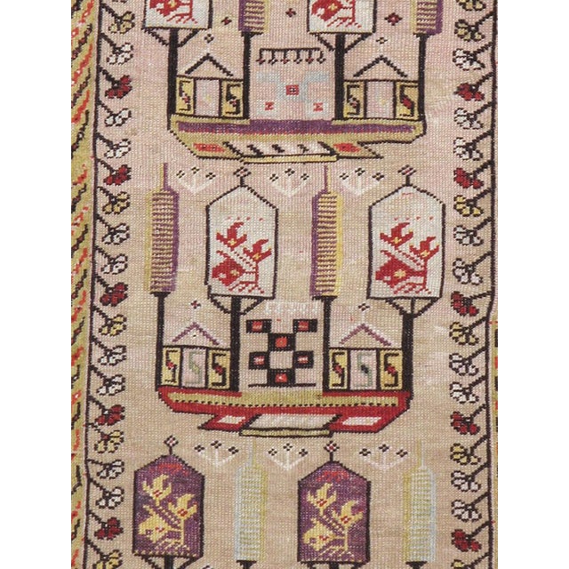An antique Turkish Ghiordes carpet from the first quarter of the 20th century in shades of light blue, purple, red, and...