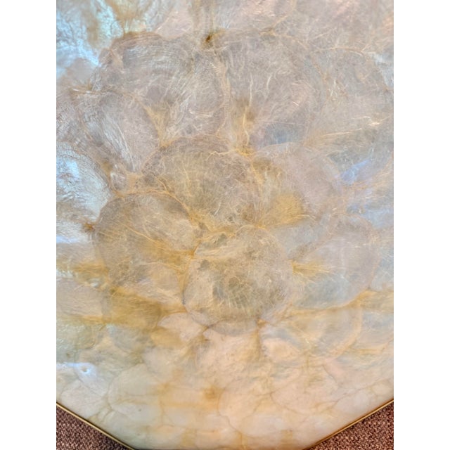 Vintage octagonal tray crafted from natural capiz shell panels with a warm ivory glow and brass-tone edging. Made in the...