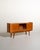 Teak frame with shaped sliding doors, a central compartment with smoked glass, three lower drawers, and slanted dark wood...