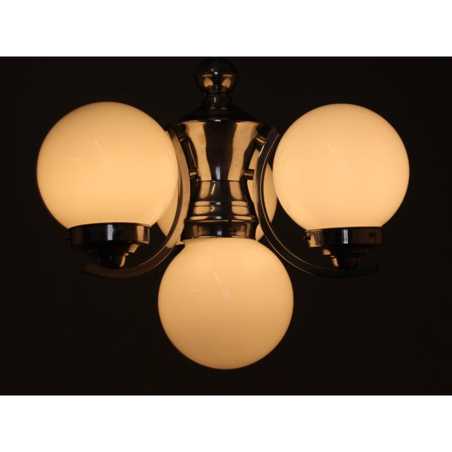 This three-arm Bauhaus chandelier consists of three white overlay glass spheres (all undamaged) and solid chrome-plated...