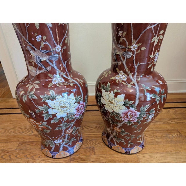 These matched floor vases feature an elegant, elongated baluster silhouette with flaring trumpet necks, tapering bodies,...