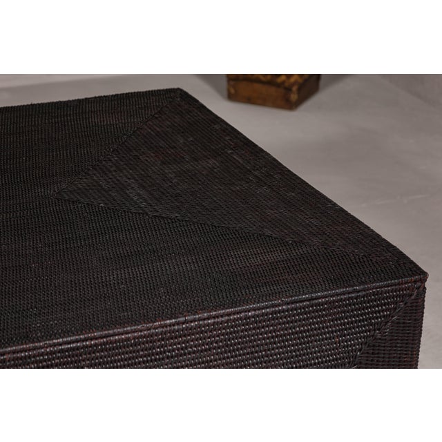 A Country style woven rattan dark brown Parsons legs coffee table with rectangular top. This Country style dark brown...