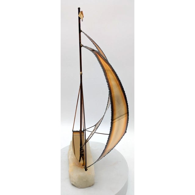 Beautiful vintage brass sailboat sculpture mounted on a solid marble base. This elegant nautical piece features detailed...