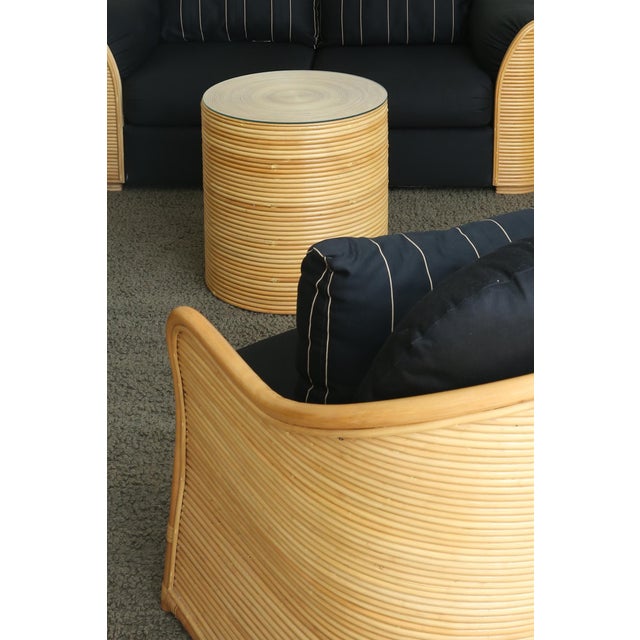 A sculptural lounge chair defined by its curved reeded wood frame and black upholstery. The rounded arms and wrapped form...