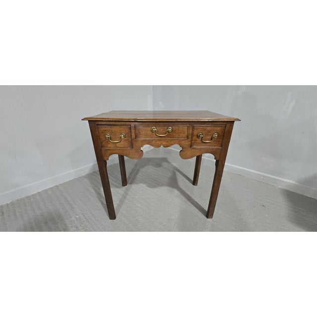 A very good Georgian oak three drawer lowboy, with original brass swan necked handles, and in original overall very good...