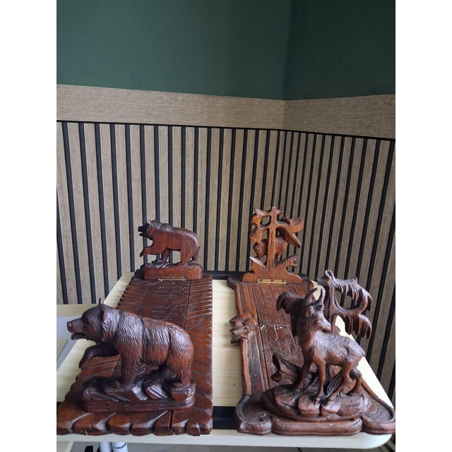 Two walnut wood bookends—authentic pieces from the Black Forest and Brienz (Switzerland)—featuring masterful, detailed...