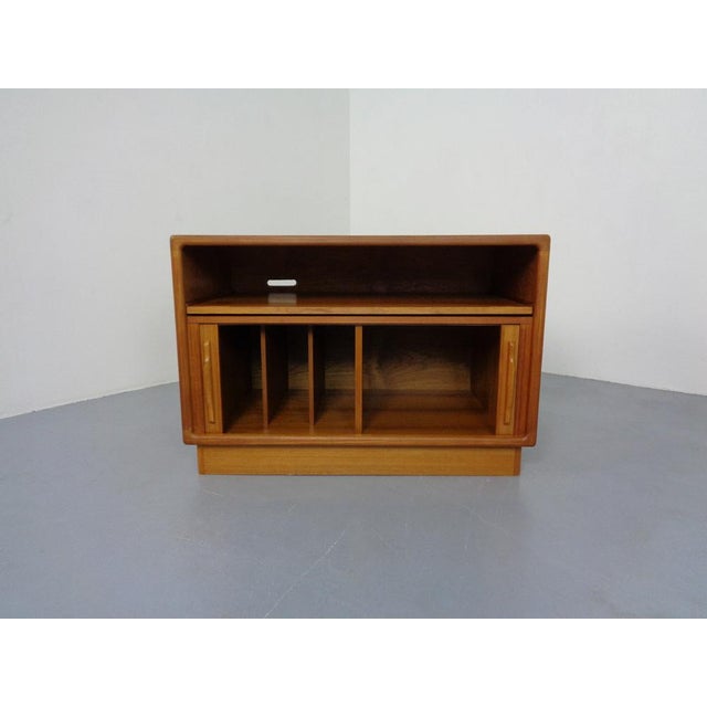 Small sideboard with rolling doors from Dyrlund in teak disappearing into the sides. I have official proof of authenticity...