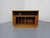 Small sideboard with rolling doors from Dyrlund in teak disappearing into the sides. I have official proof of authenticity...