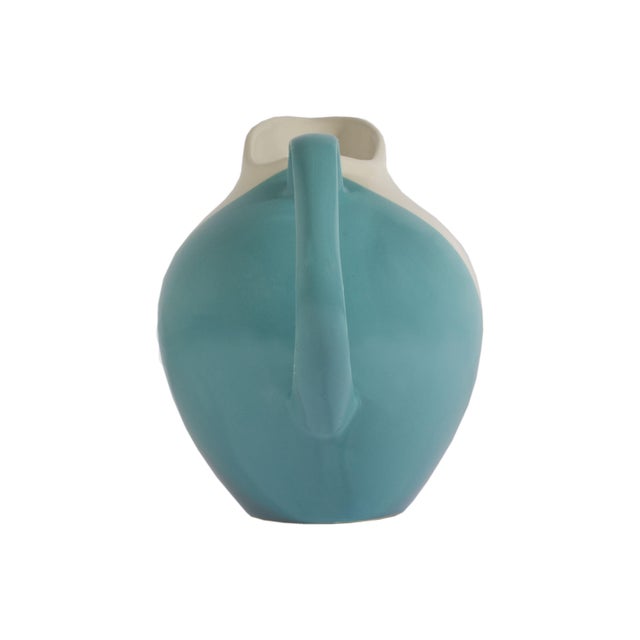 A ceramic pitcher designed by Hungarian-American ceramic artist Eva Zeisel (1906-2011) and produced by Hall China . The...