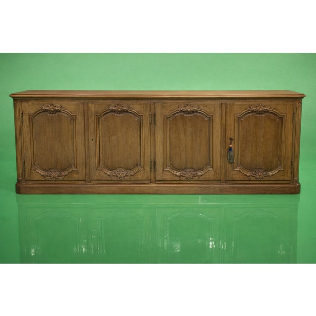 Baker Furniture French Provincial four-door enfilade sideboard, crafted in oak and richly embellished with traditional...