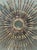 This striking sunburst wall sculpture is a quintessential example of Mid-Century Modern and Brutalist design. Handcrafted...