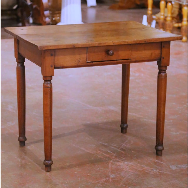A charming French Louis Philippe bedside table crafted in wild cherry circa 1840, featuring a clean, functional silhouette...